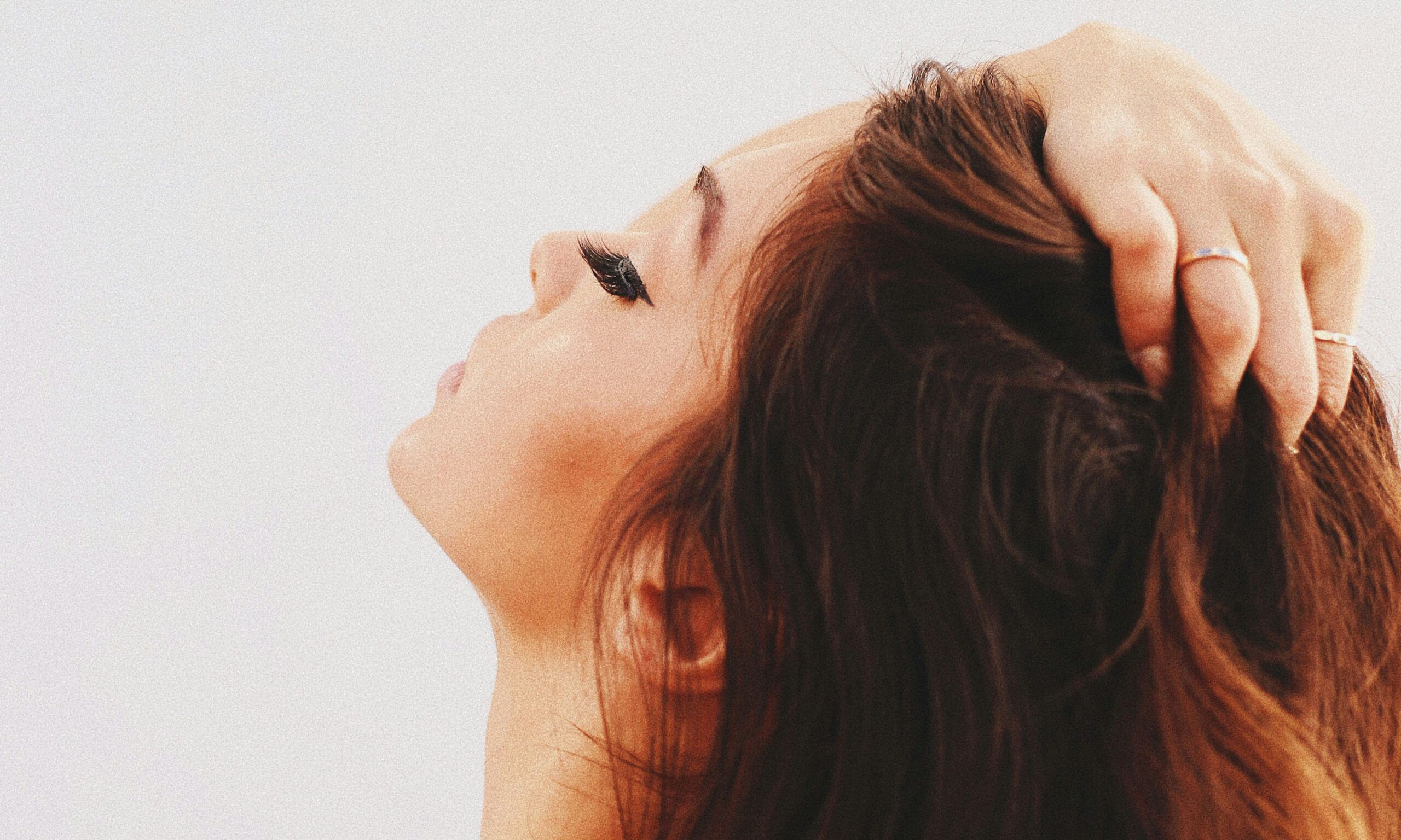 woman looking up touching hair