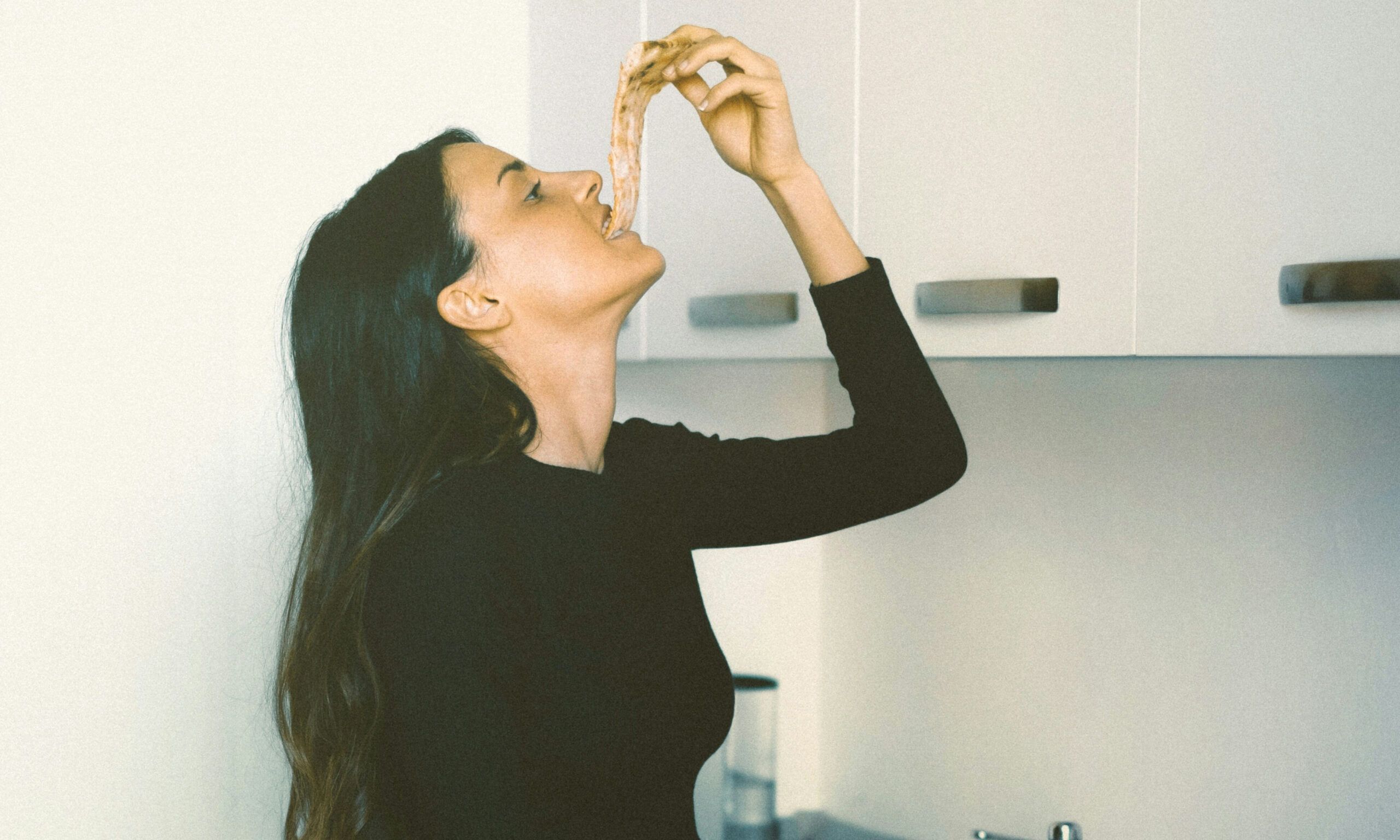 woman eating a slice of pizza