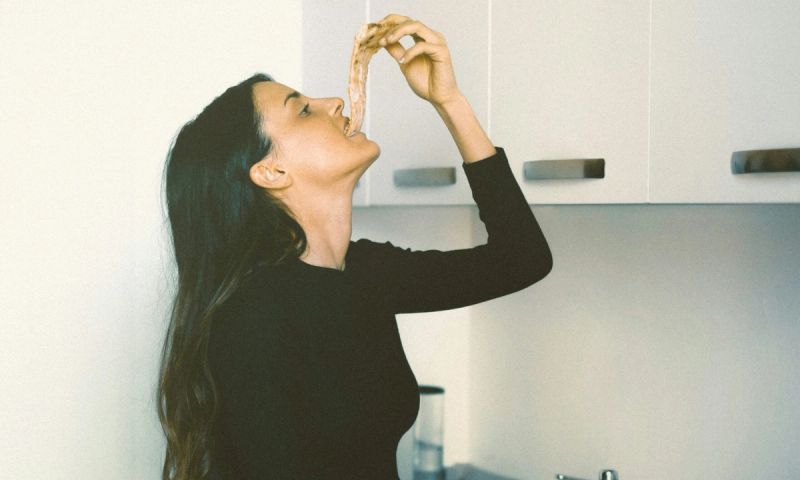 woman eating a slice of pizza