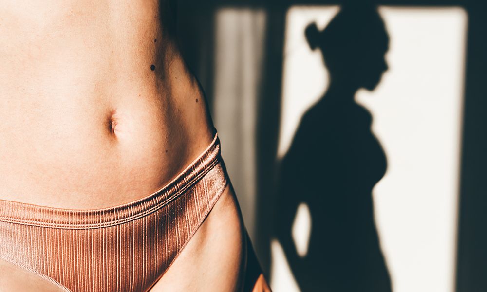 Naked abdomen with many birthmarks.