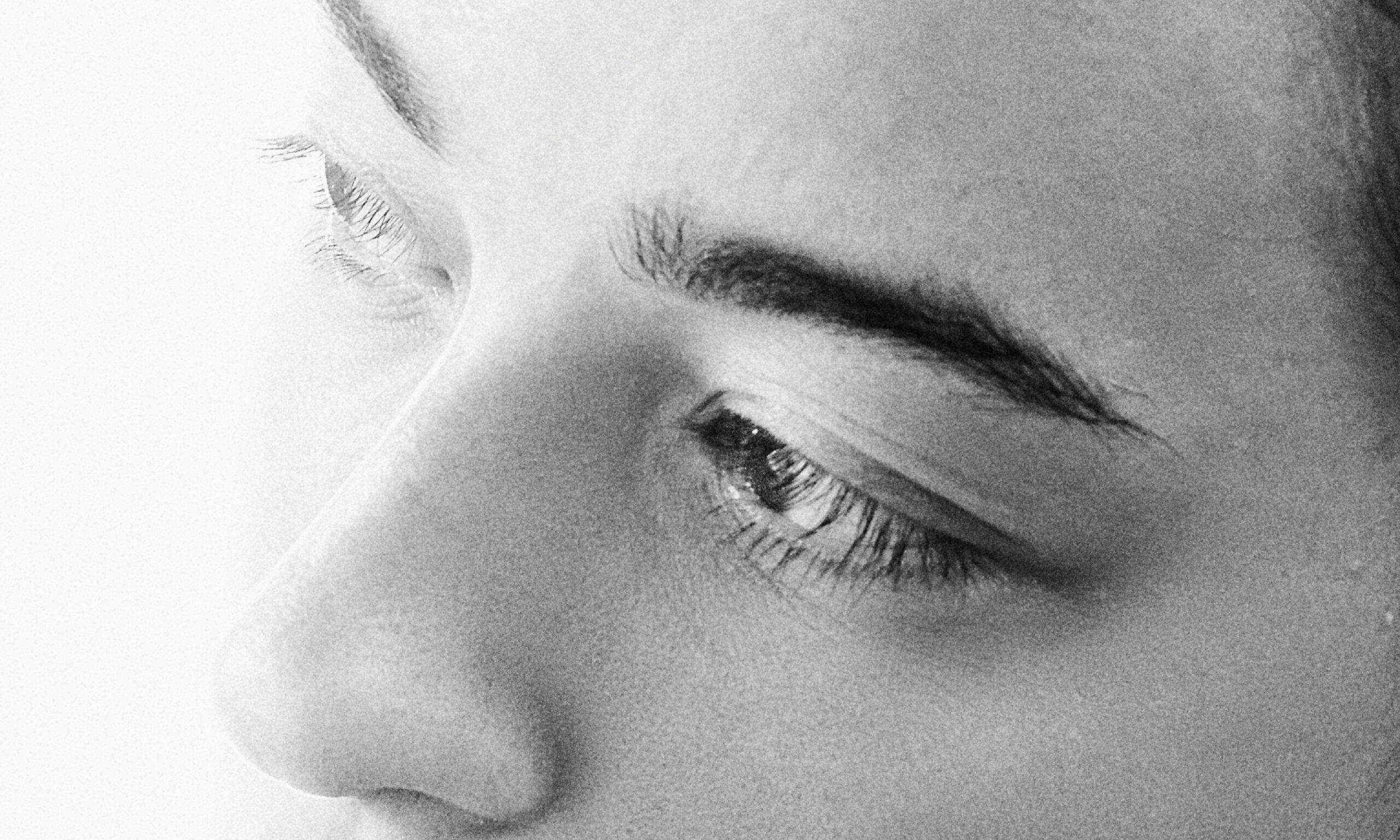 black and white image of woman's nose, eyes and eyebrows