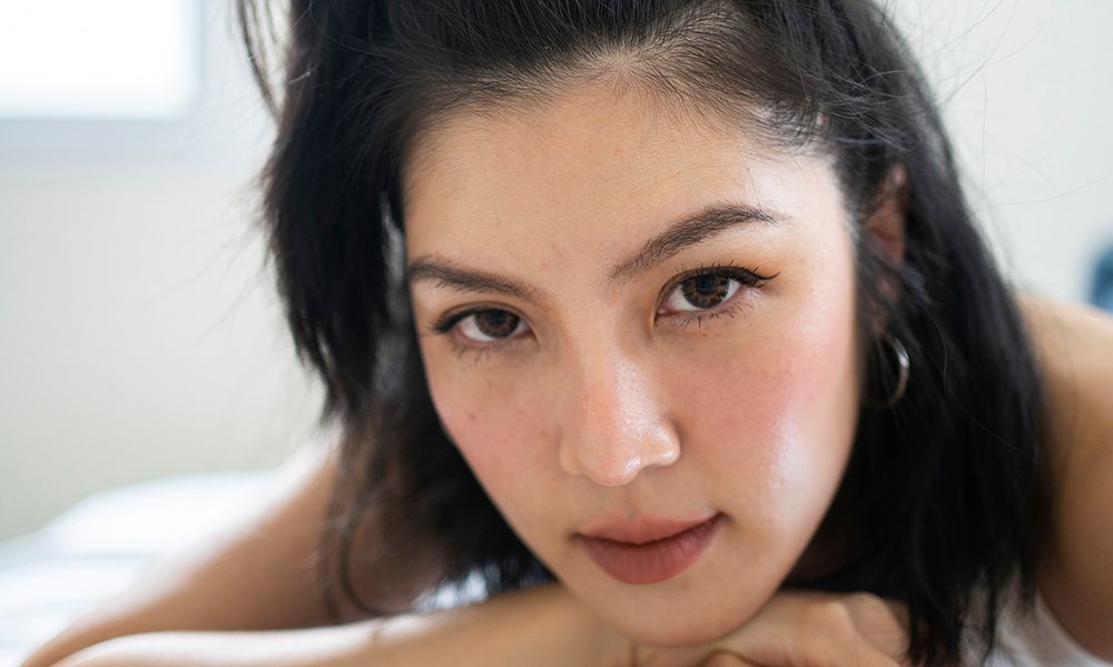 portrait asian female young adult feeling relax on cozy bed after wake up in the morning