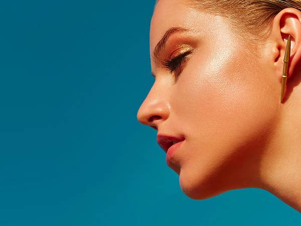 up-view of woman's jawline and side profile on sky-blue background