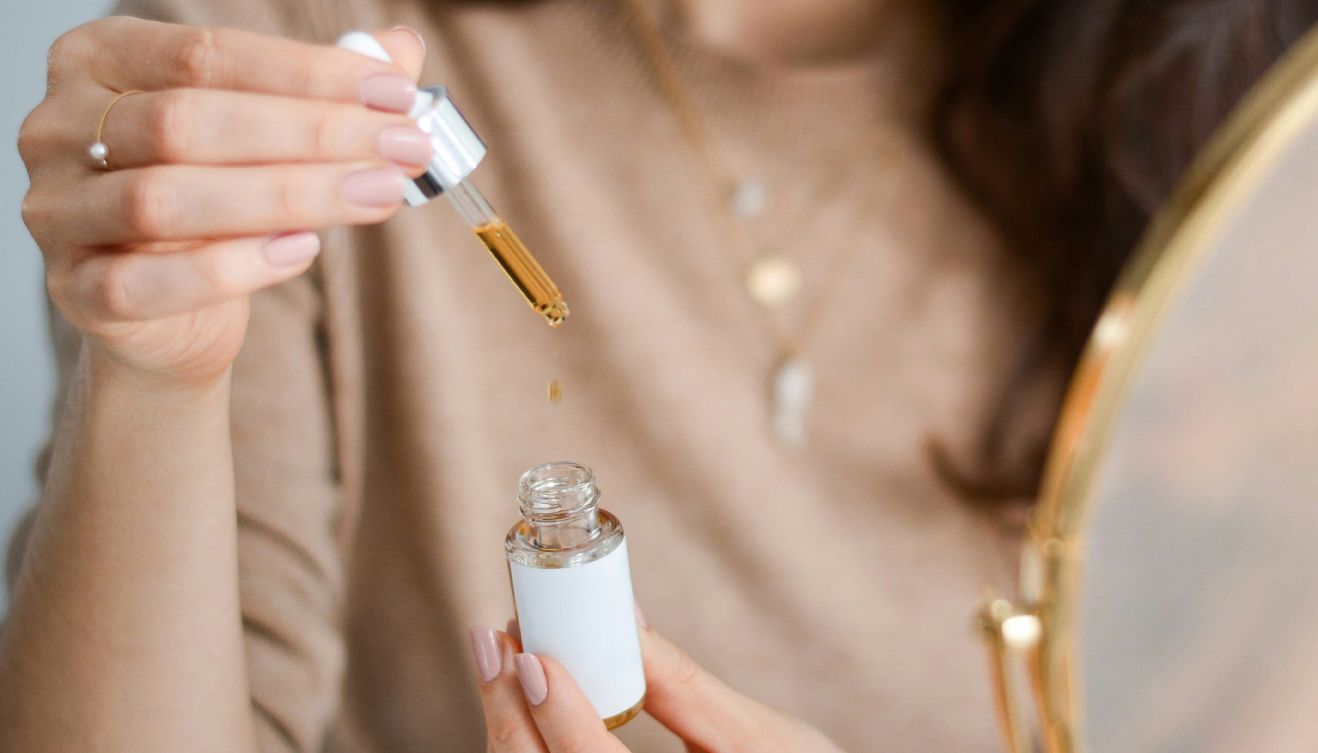woman holding bottle of skin-care oil