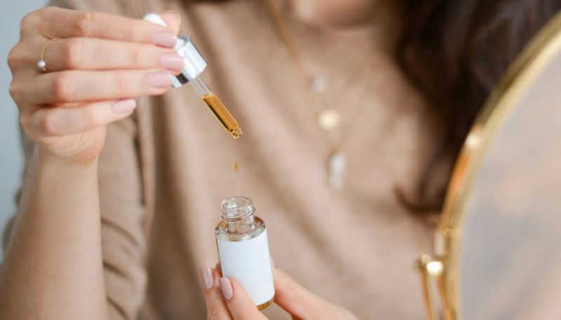 woman holding bottle of skin-care oil