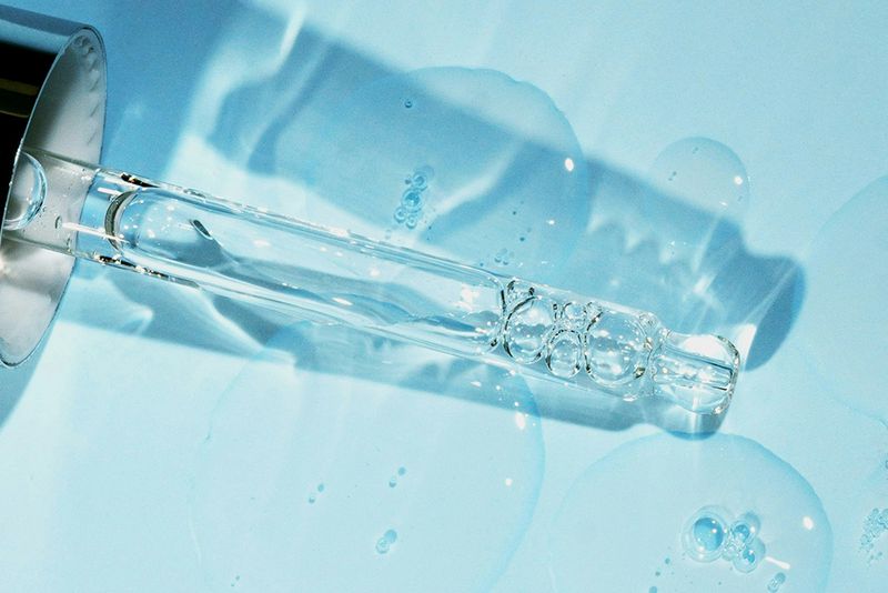 serum in dropper on light blue background