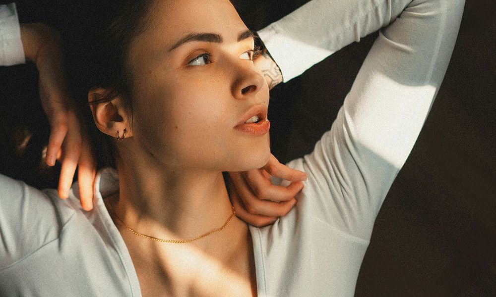 woman laying down with hands on shoulders