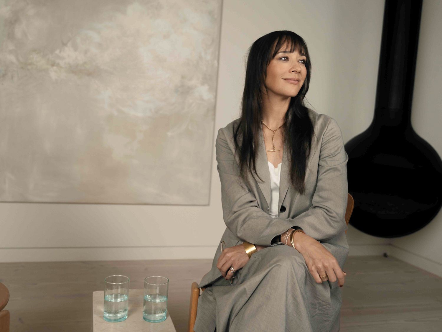 Rashida Jones sits in a gray suit during a portrait session for Hårklinikken.