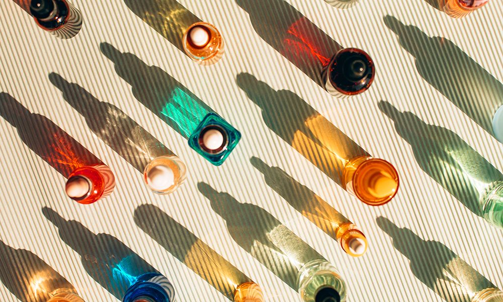 Set of three glass vials on striped beige background. Concept of skin care procedures for health and wellbeing. Sunlight makes shadows and illuminating reflections from bottles. Flat lay style. . Pattern