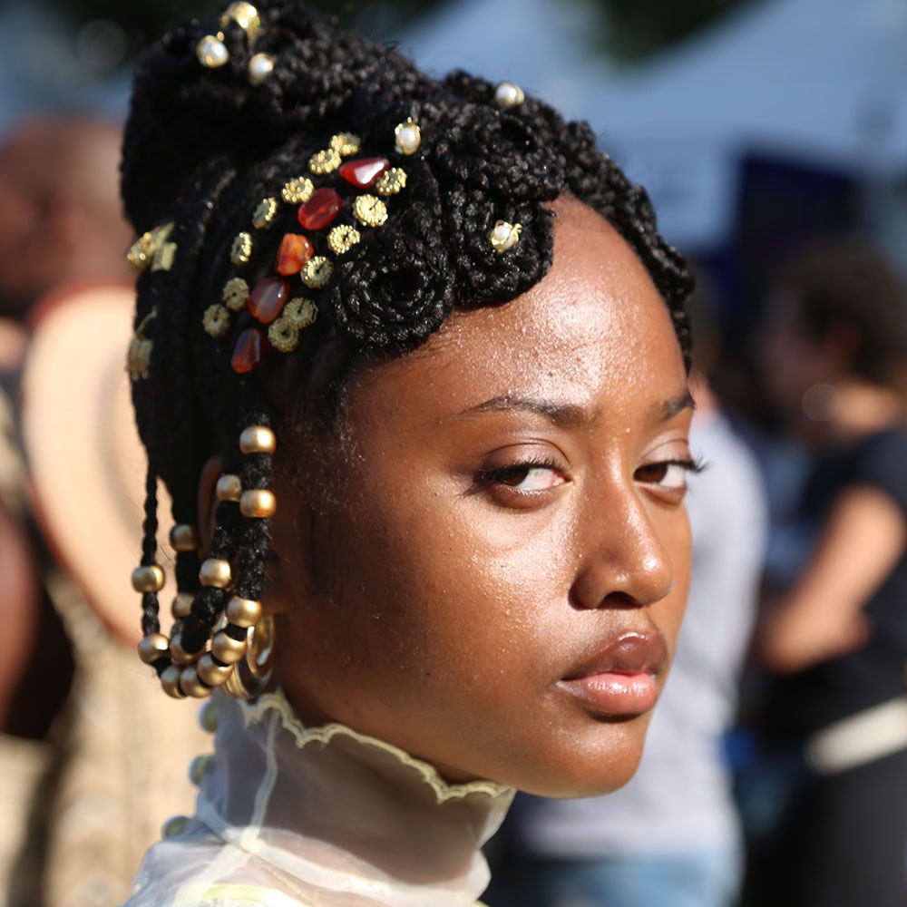 Close up of woman with beaded, braided updo hairstyle