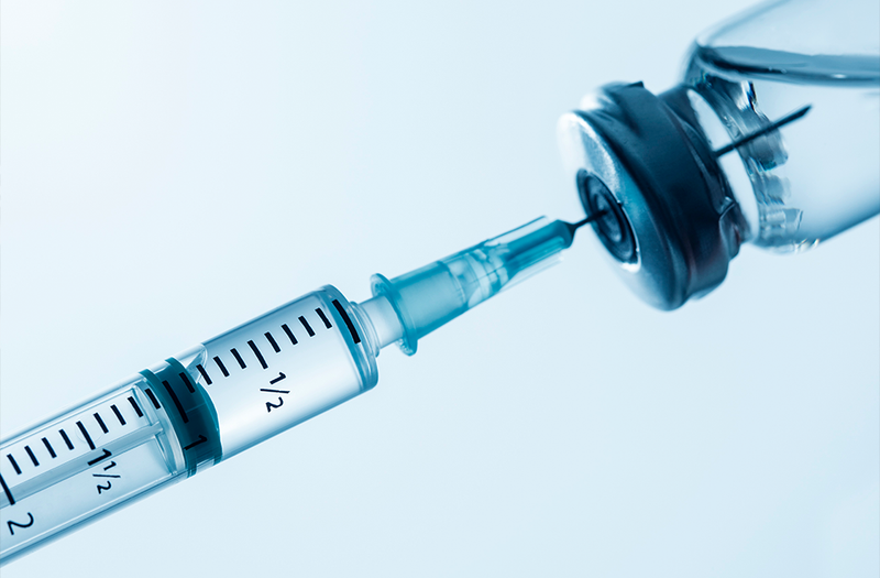 syringe and vial on blue background