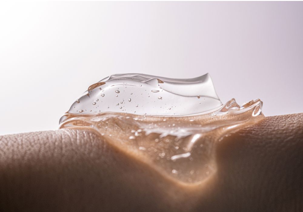 Close-up of a clear, gel-like serum with air bubbles resting on textured skin, illustrating a lightweight, hydrating skincare formula