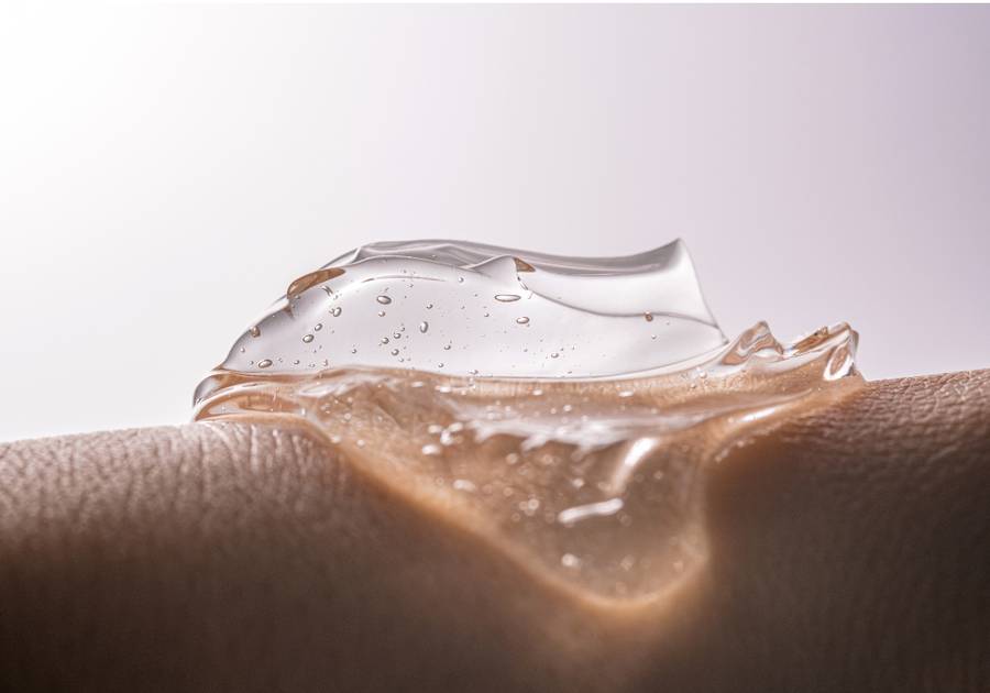 Close-up of a clear, gel-like serum with air bubbles resting on textured skin, illustrating a lightweight, hydrating skincare formula