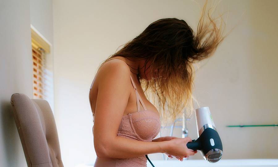 woman on chair with hair dryer