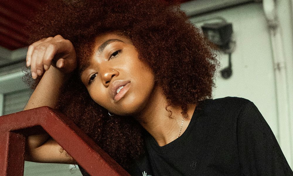 woman with afro and glowy skin