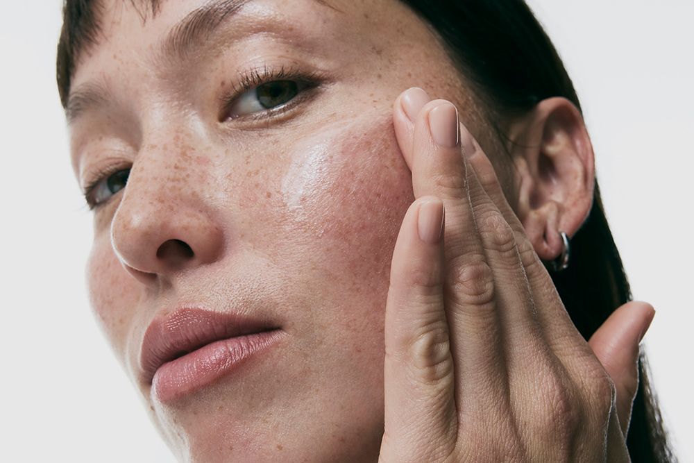 woman using vitamin c serum on face