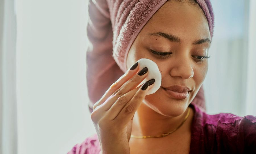 Woman Cleansing Face with Cotton Pad