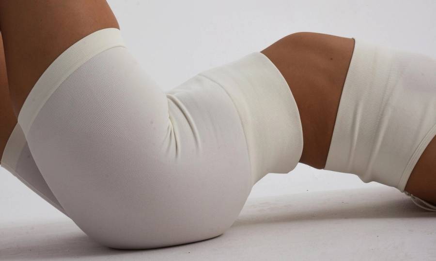 mid view of woman in white shorts and white bra cami