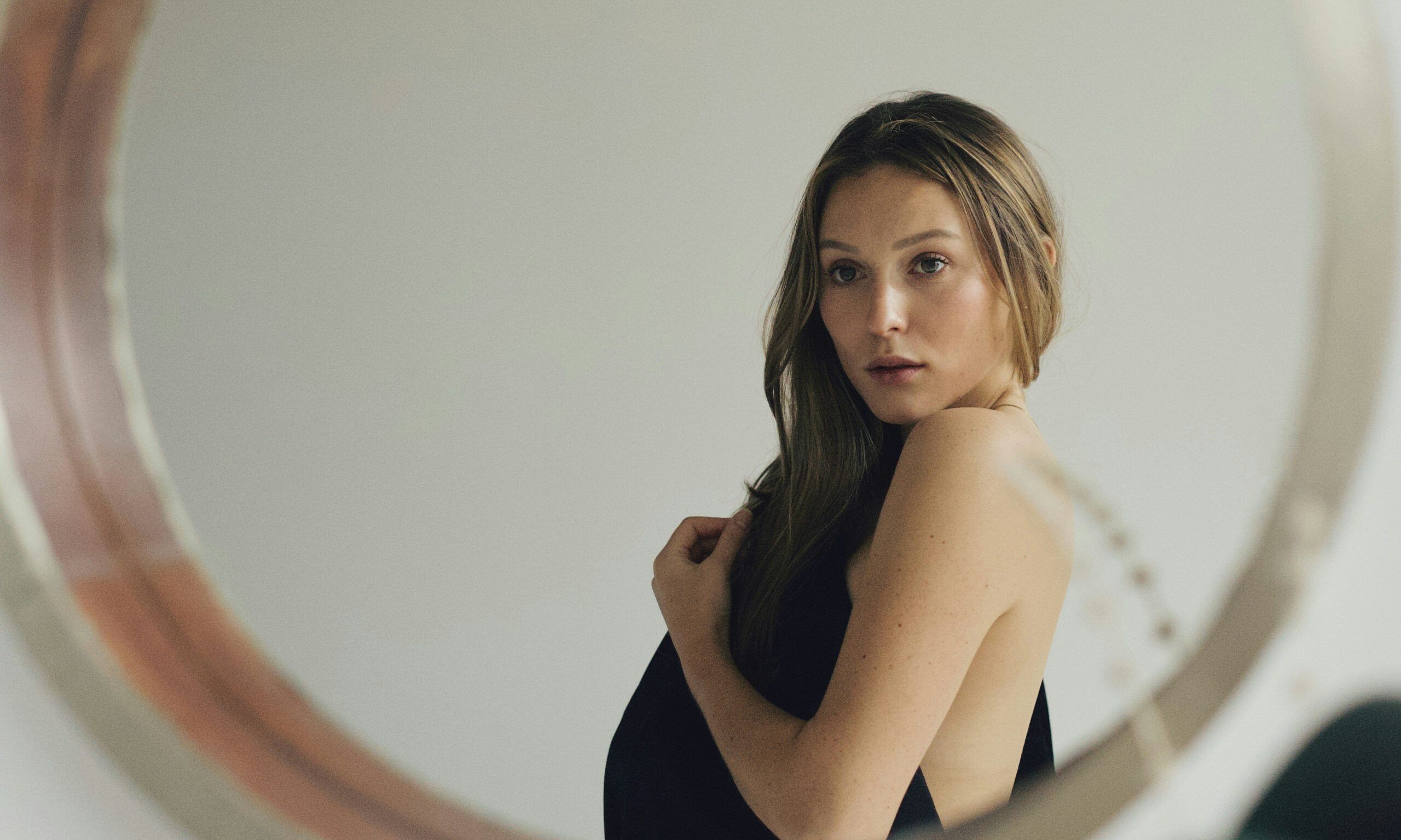 woman looking at face in mirror