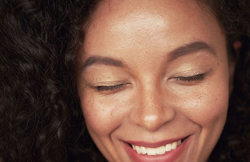 woman smiling with eye closed