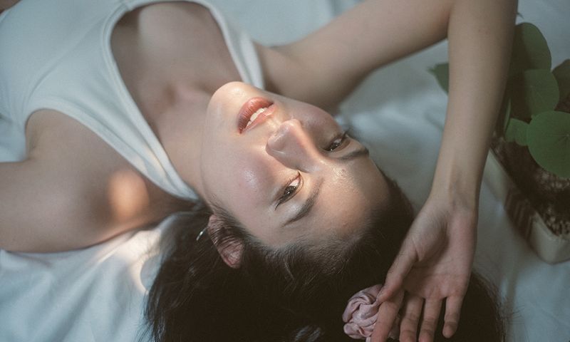 close up face portrait asian female young adult feeling relax on cozy bed after wake up in the morning