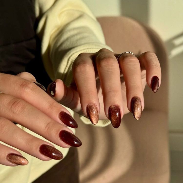 Cola-inspired nail art featuring glossy brown and bronze shimmer polish on almond-shaped nails, mimicking the rich, fizzy color of Diet Coke