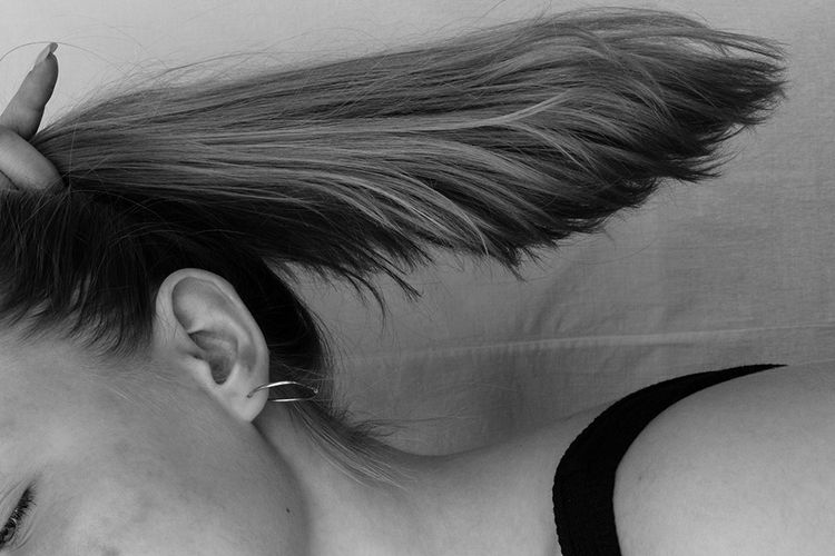 black and white photo of woman's hair held in ponytail