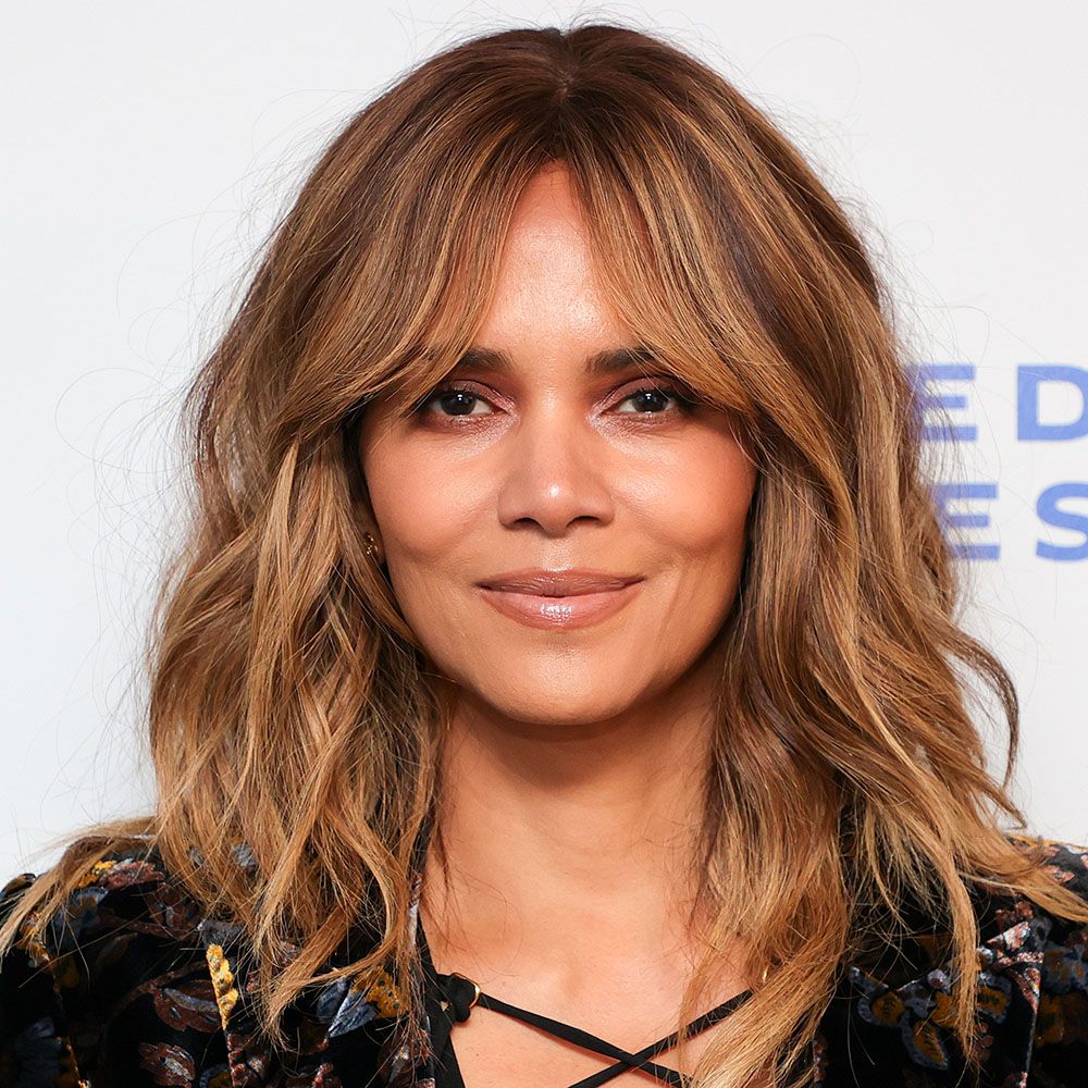 Close view of Halle Berry with caramel-colored, medium length wavy hair and curtain bangs