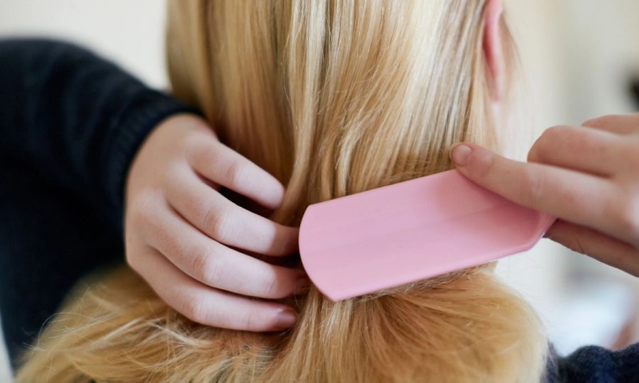 woman brushing hair with pink hairbrush