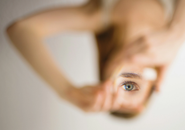 Close-up of a woman's eye reflected in a mirror showing healthy skin