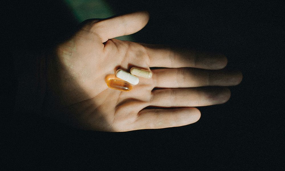hand holding supplements in shadows