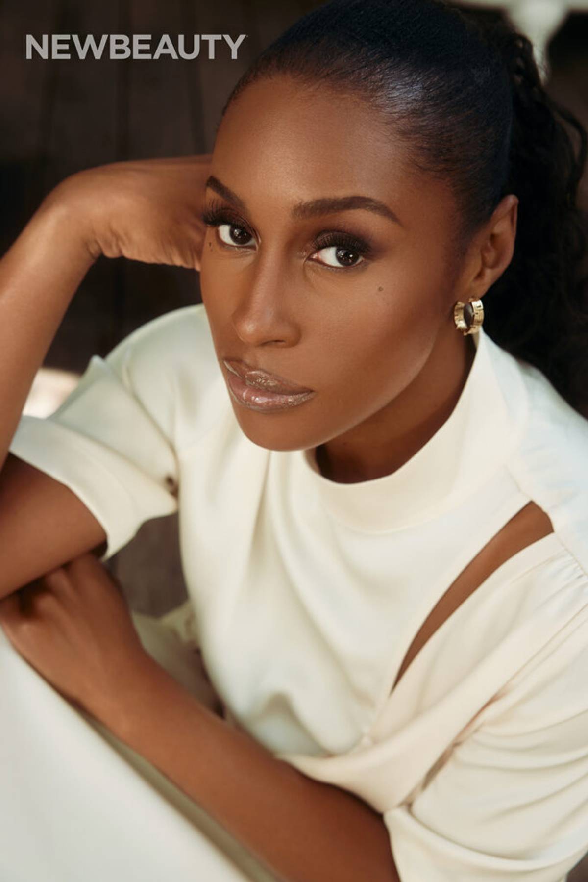 Issa Rae wearing white cut-out outfit and gold hoop earrings