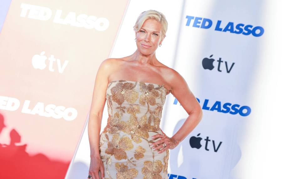 Hannah Waddingham on the Ted Lasso premiere red carpet in a strapless gold floral-embroidered gown, wearing a soft glowy makeup look with her blonde hair swept back