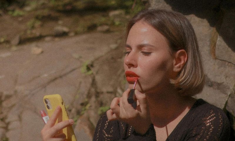 woman applying red lipstick