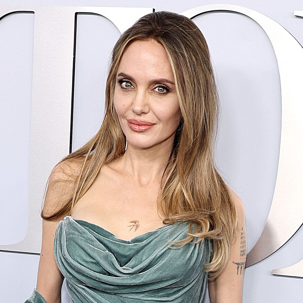 Angelina Jolie poses at Tony Awards wearing a teal velvet strapless dress