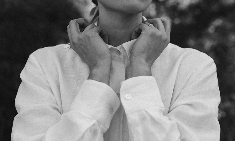 woman holding shirt over neck