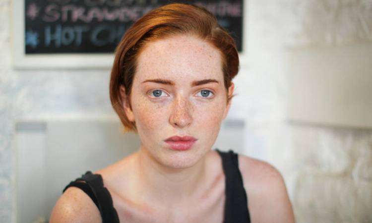 red haired woman looking into the camers