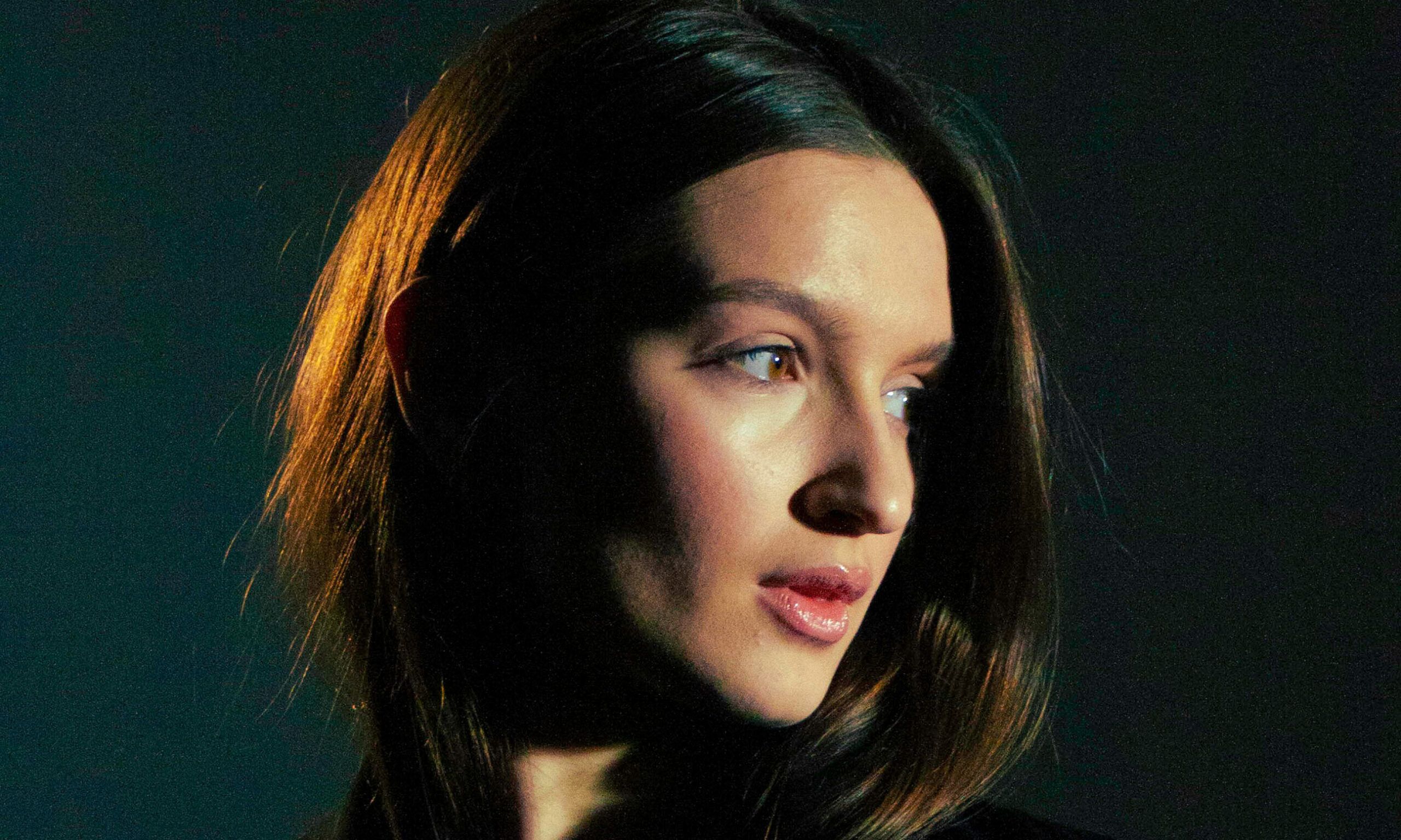 brown haired woman in front of black background