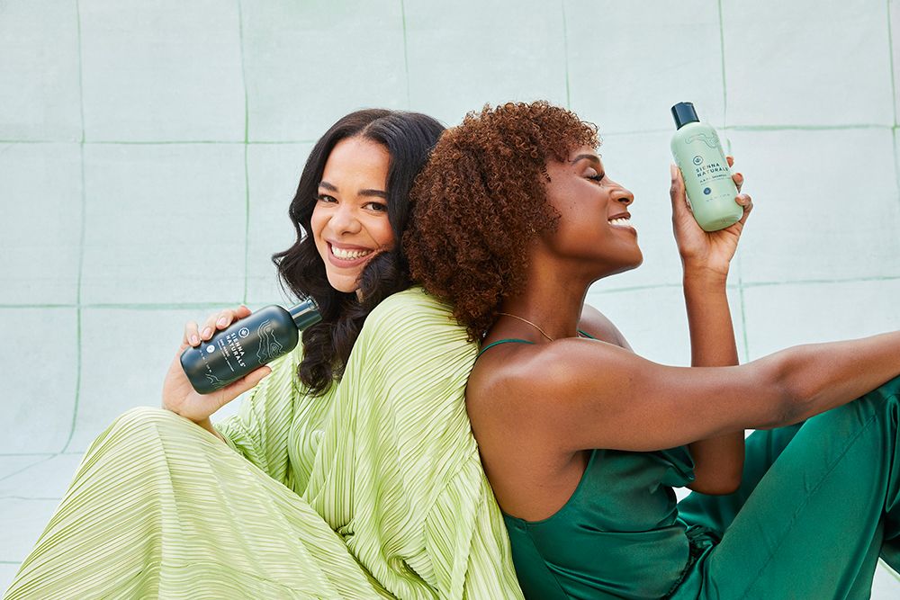 Hannah Diop and Issa Rae posing in green dresses with Sienna Naturals hair products