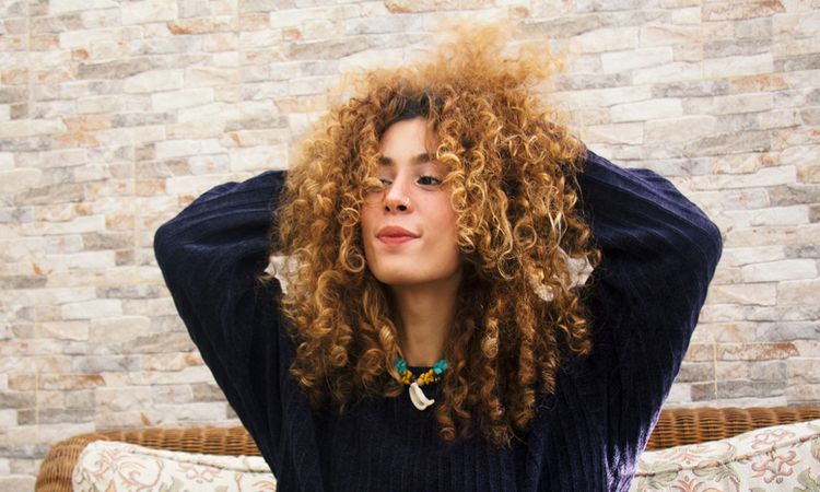 woman with hands in curly hair