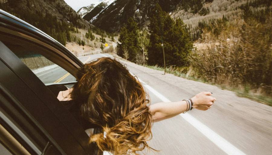 woman in car with hand out the window