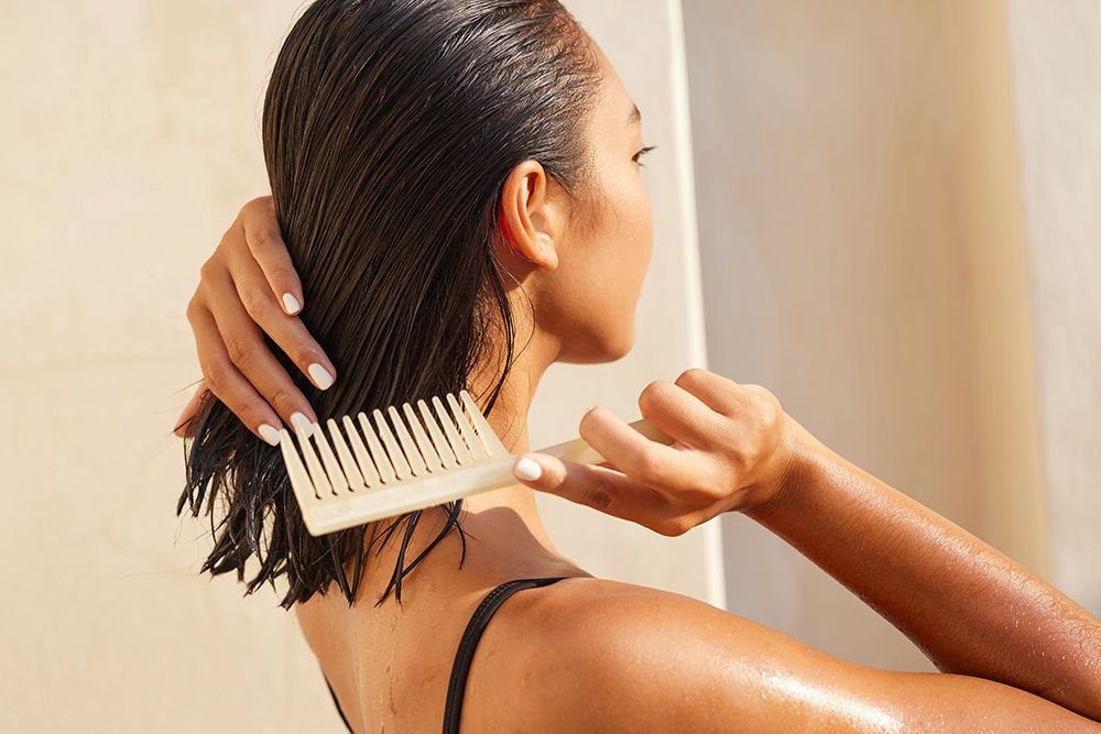 Woman Combing Wet Hair With Wooden Comb In Bright Sunlight, Emphasizing Haircare, Wellness And Summer Vibes.