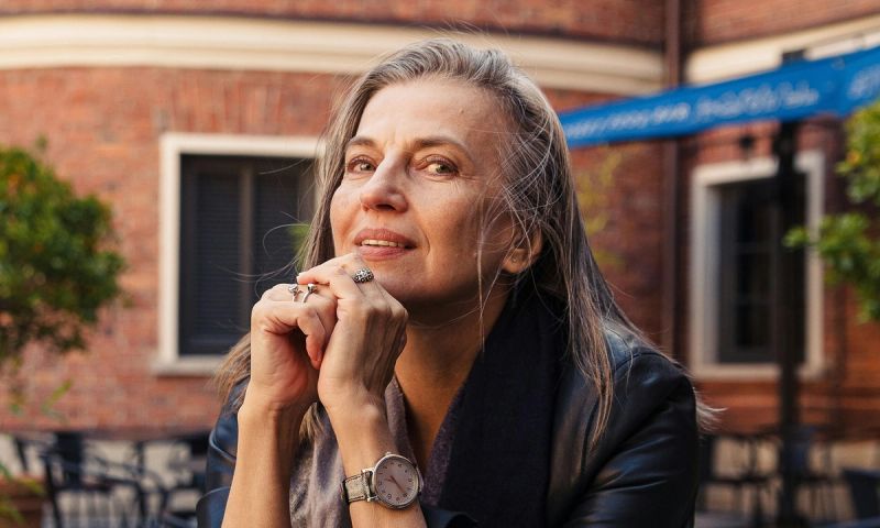 woman with silver hair sitting at a table outdoors
