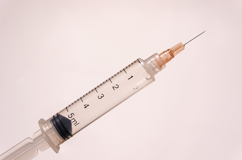 syringe on pink background