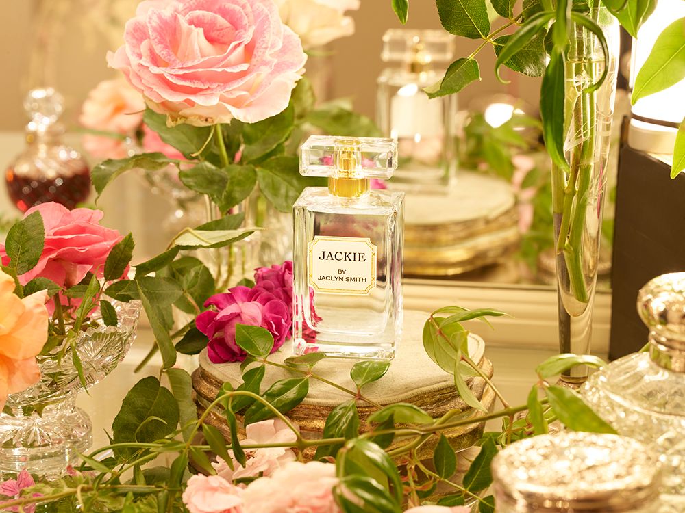 Bottle of Jaclyn Smith fragrance staged on floral set