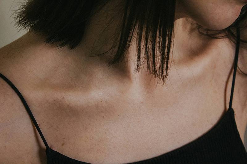 woman in black tank top. Focus on chest