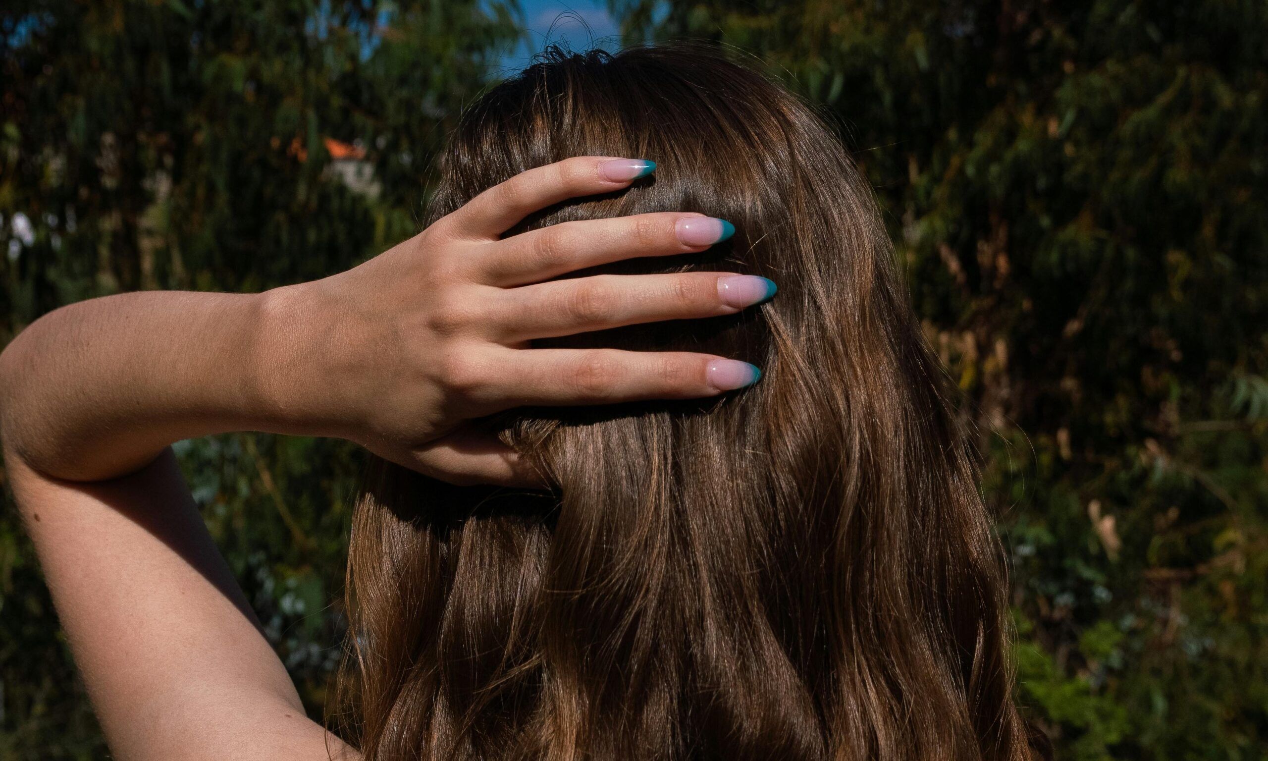 back view of woman touching head with her hand