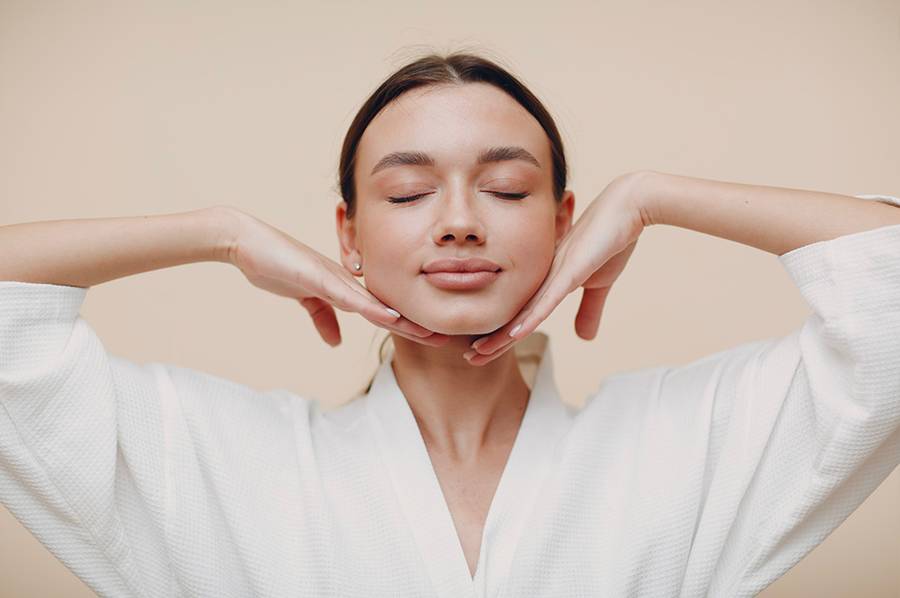woman with eyes closed and hands on chin