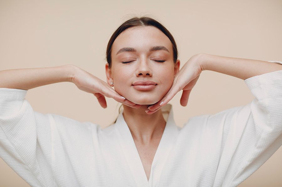 woman with eyes closed and hands on chin