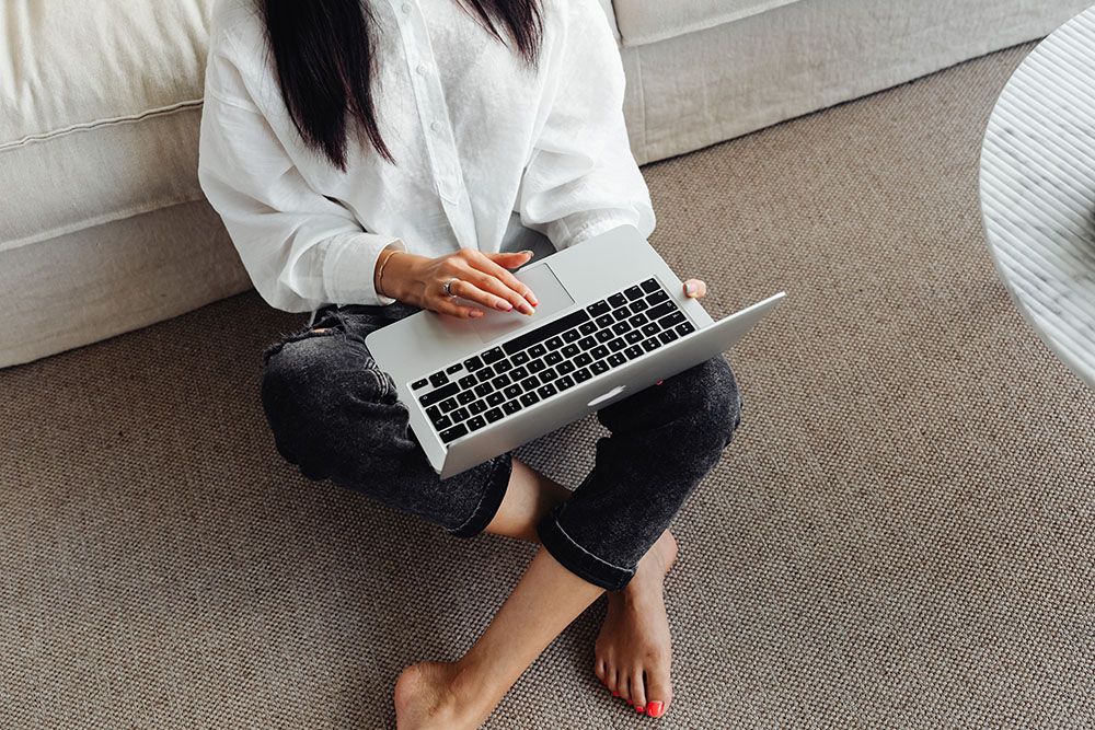 woman sitting on the floor with a laptop